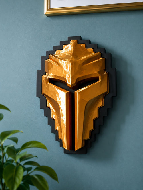 A Tibia Golden Helmet wall sculpture mounted on a textured blue wall, framed by a gold picture frame at the top and green leaves at the bottom left.